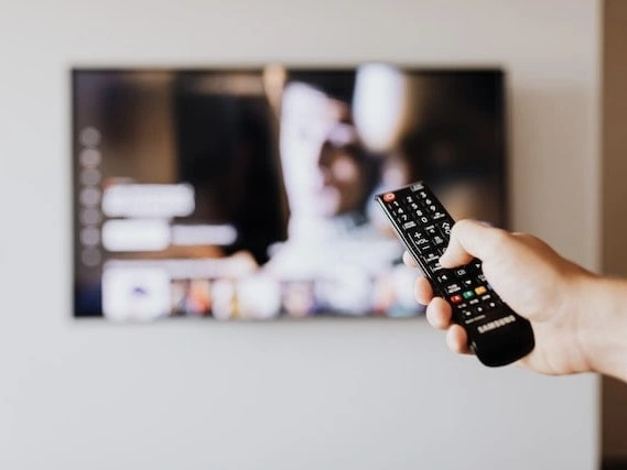 Someone is changing the channel on a TV using a remote control. 