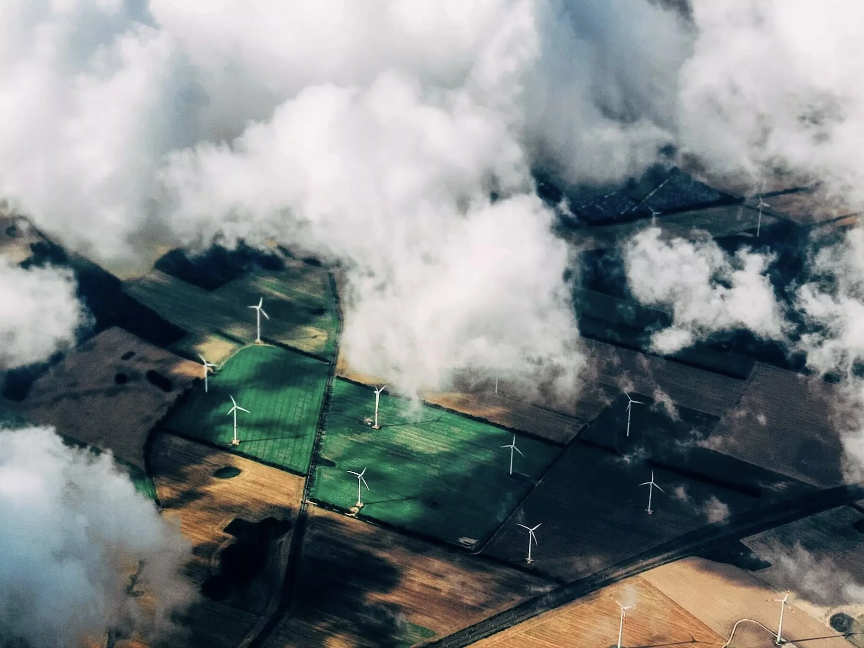 A wind farm seen from above through clouds.  