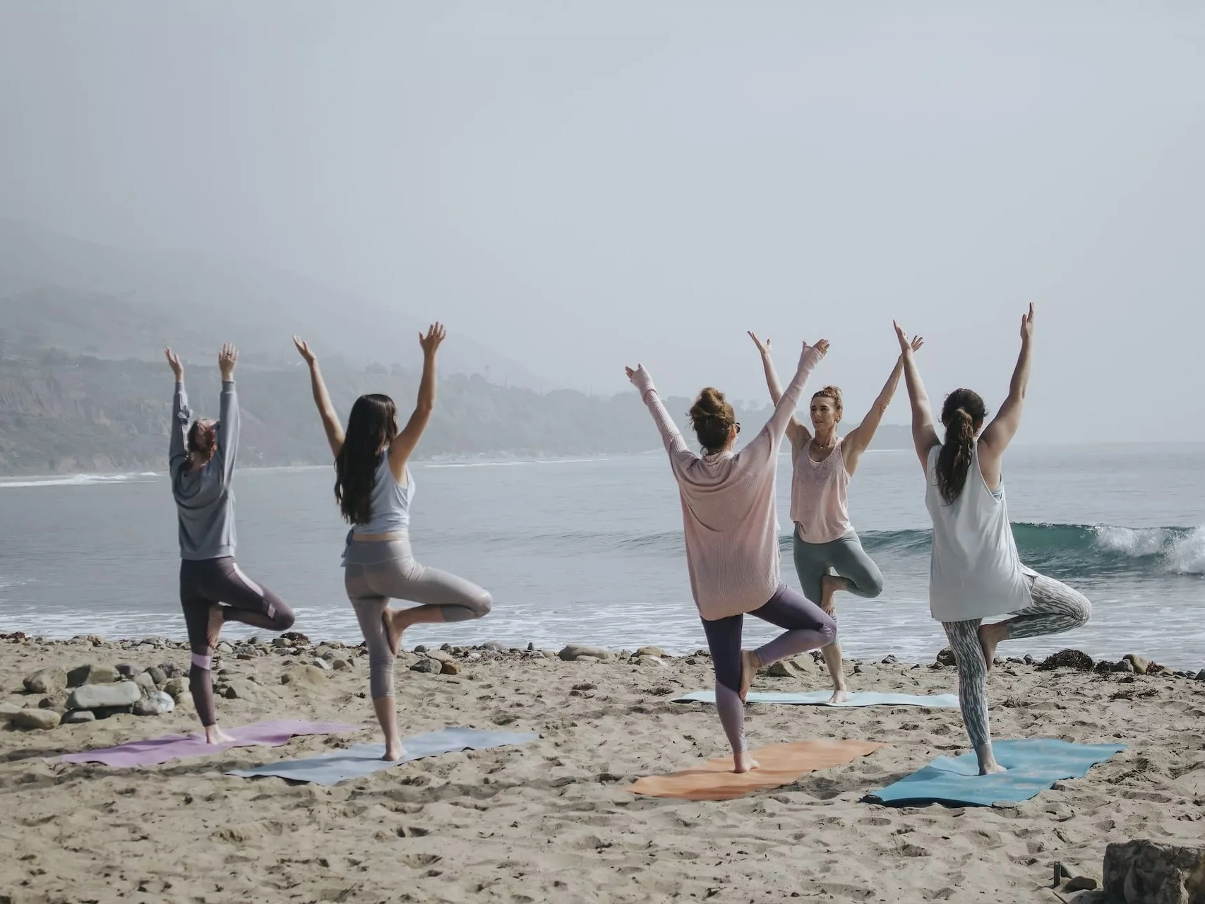 People doing yoga on the beach. 