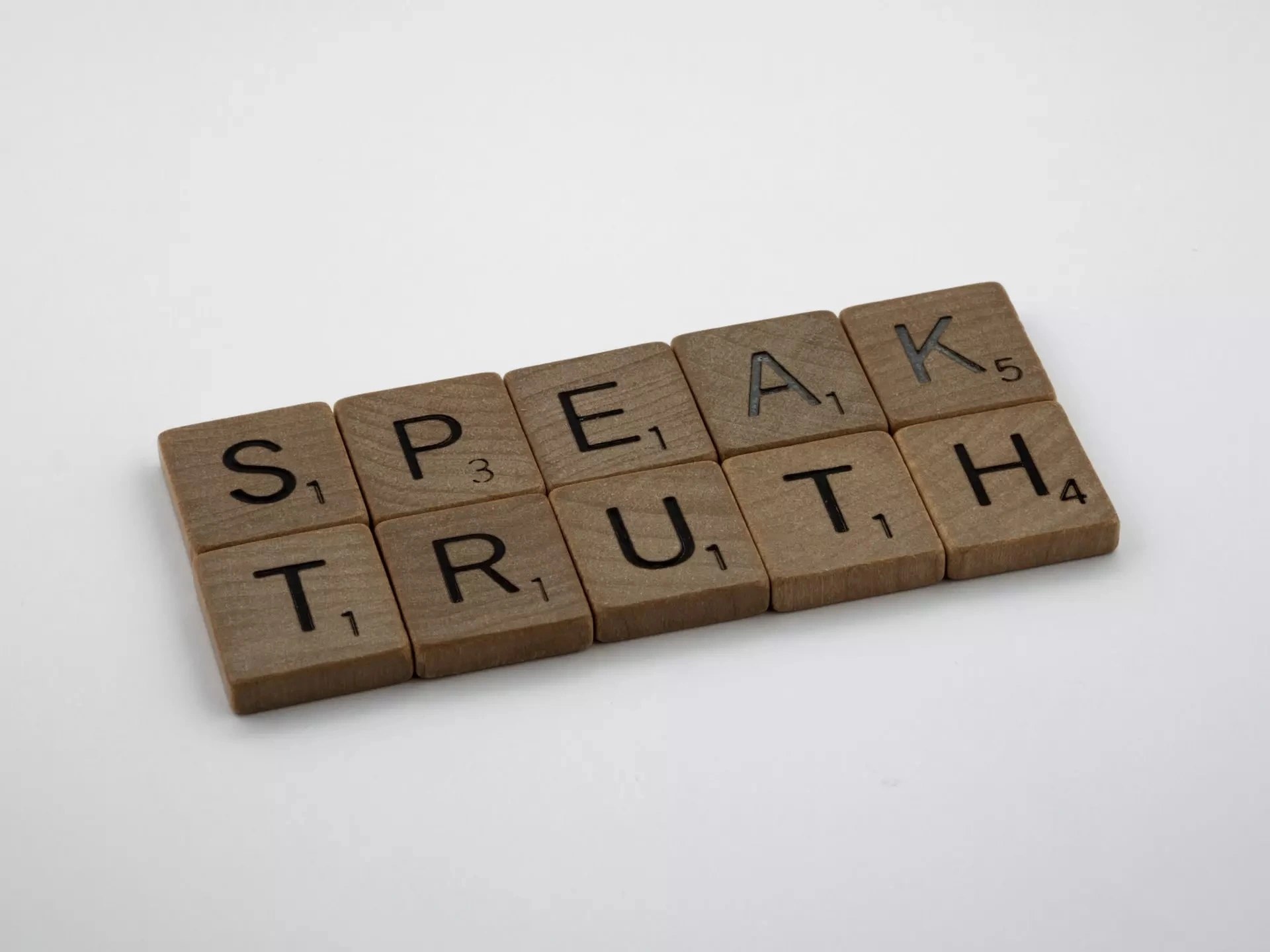 Scrabble tiles spelling out the words "speak" and "truth". 