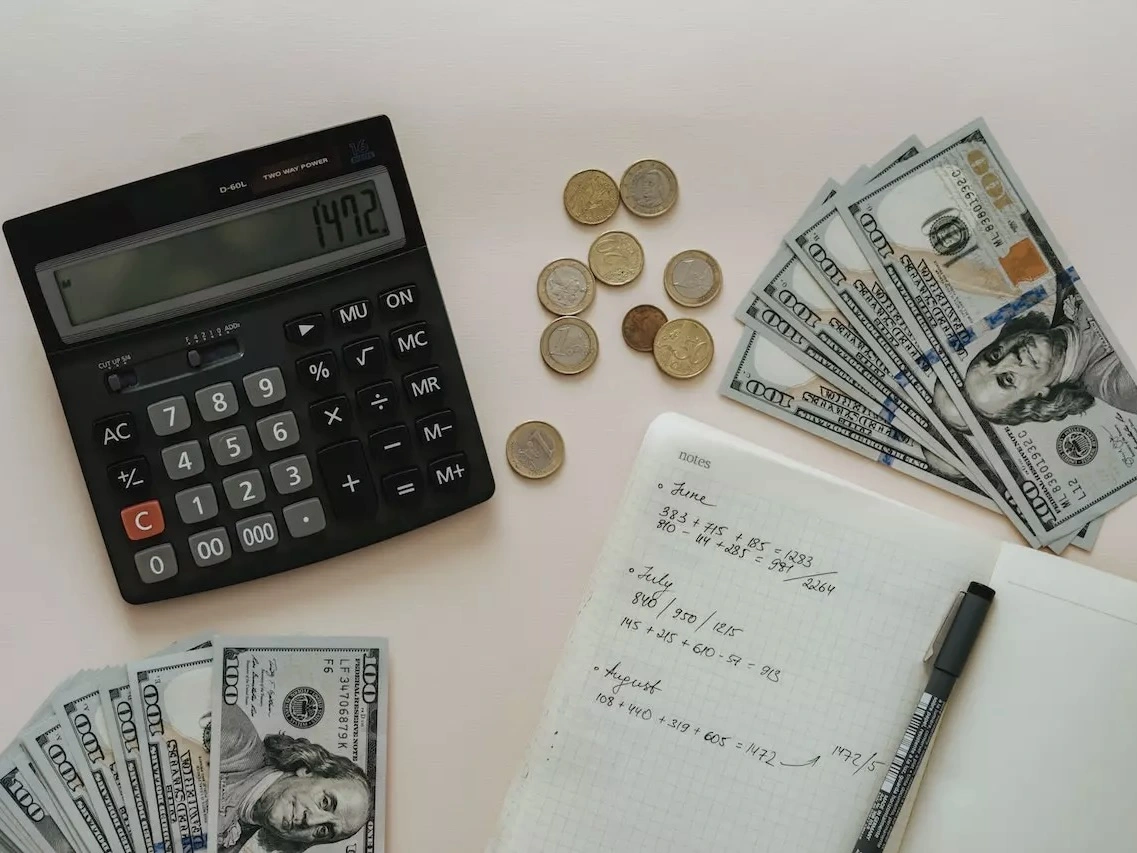 A budgeting journal, calculator and some cash. 