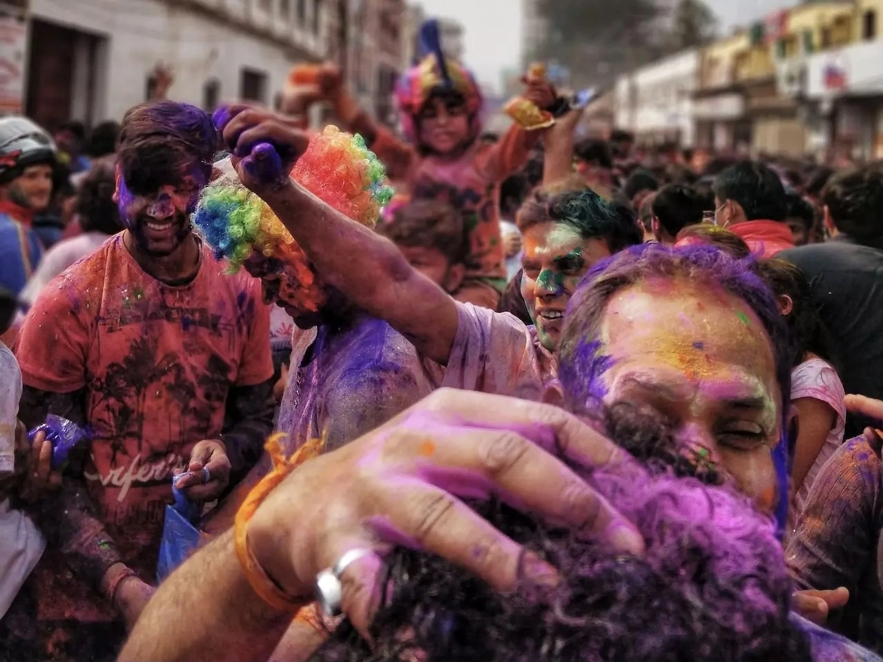 Festival goers covered in coloured powders. 