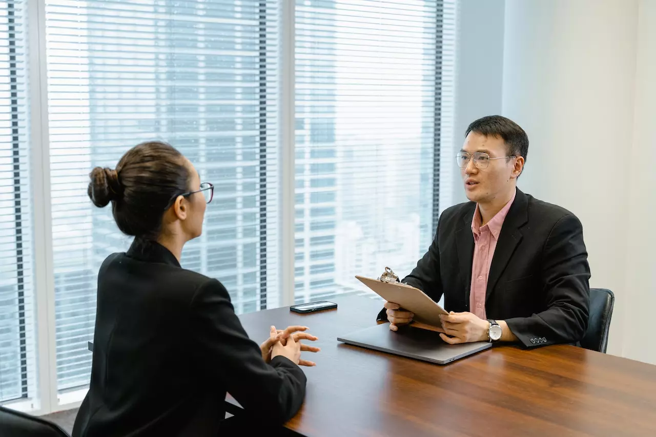 A man and woman are talking during a job interview.